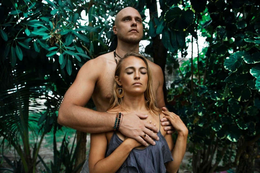 Sacred sexuality; man standing behind a woman while feeling her heart