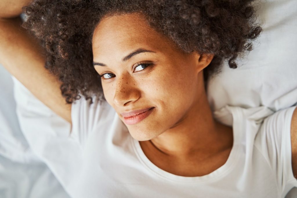 Female With Curly Hair Whiling Away The Time In Be