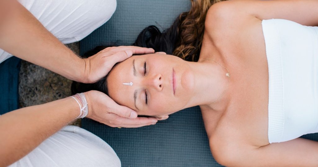A woman enjoys Ayurvedic massage in serene ambiance.